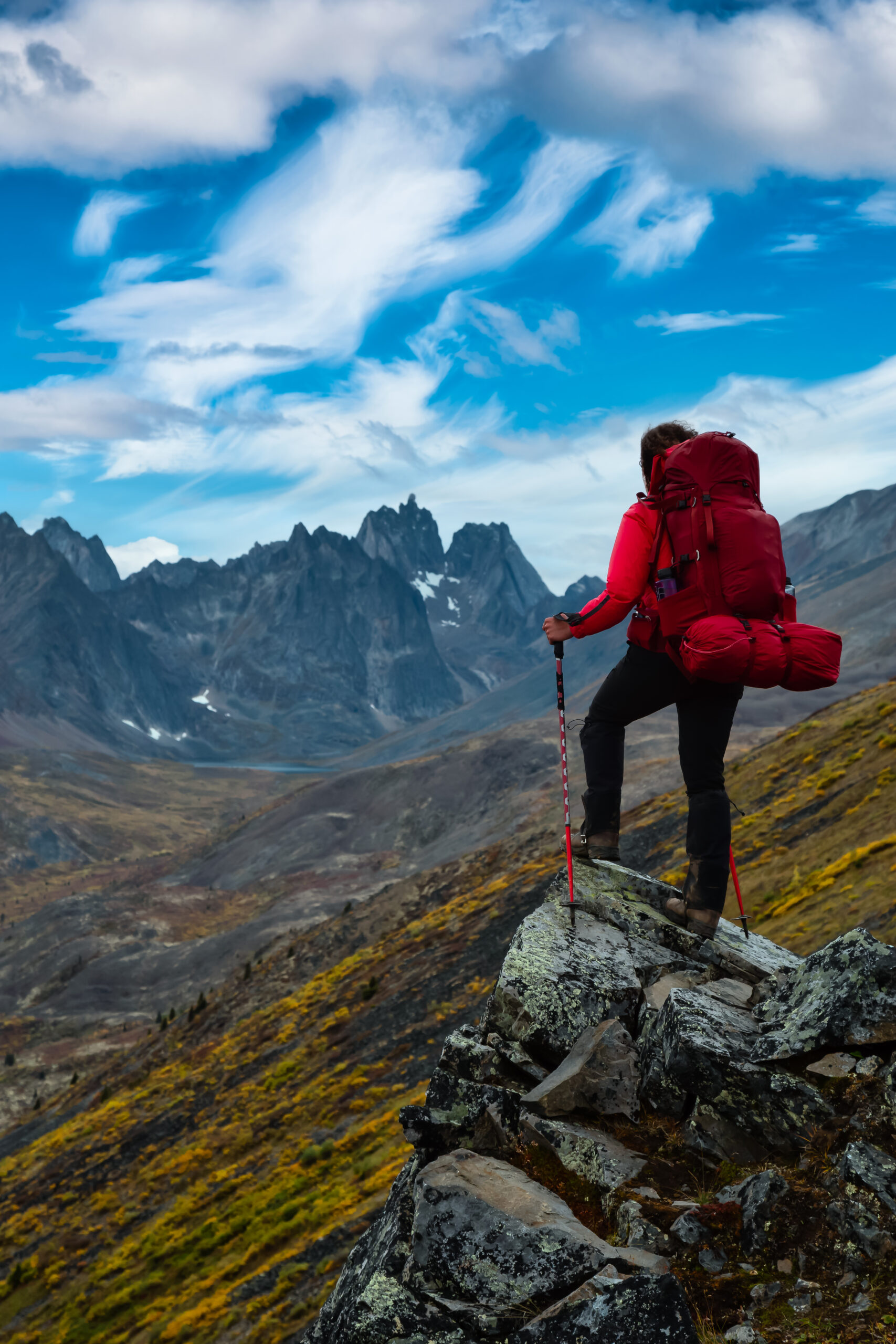 Woman Standing on Rocks looking at Scenic Mountain Peaks